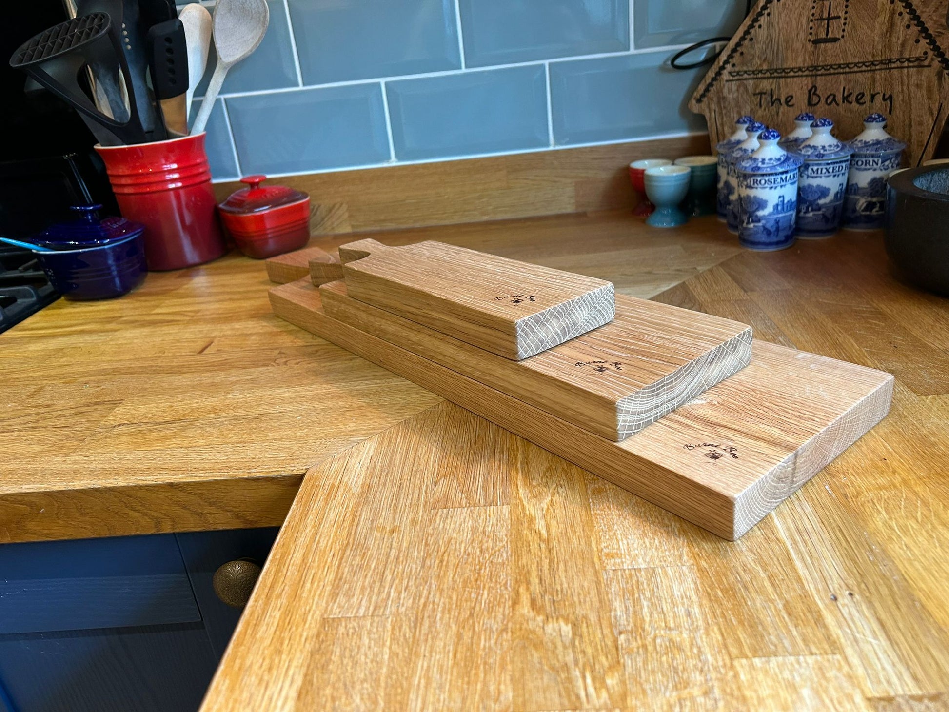 A picture of three solid oak serving platters, one on top of the other, on a kitchen worktop